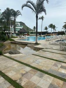 una piscina con palmeras y un complejo en Maravilhoso Flat, en Río de Janeiro