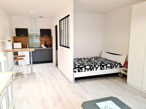 a small room with a bed and a kitchen at Studio en centre ville in Montluçon