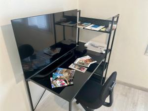 a desk with a chair and a table with magazines at Studio en centre ville in Montluçon