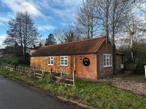 una piccola casa in mattoni sul lato della strada di Bridge Sawmill holiday cottage a Tetford