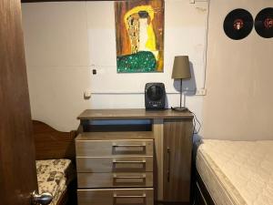 una camera da letto con una scrivania, un letto e un quadro di alojamiento pucon centrico 6 personas a Pucón