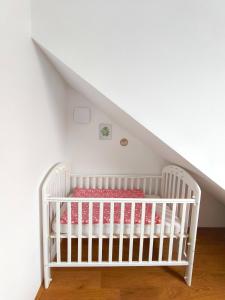 a white crib in a room with white walls at Family Nest near Ljubljana with free parking in Dobrova