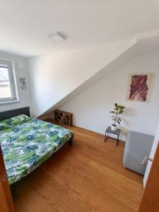 a white room with a bed and a chair at Family Nest near Ljubljana with free parking in Dobrova +11 photos