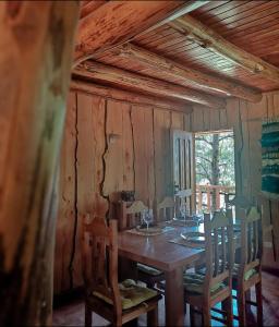 a dining room with a wooden table and chairs at Cabaña en Parcela con Tinaja in Trancura