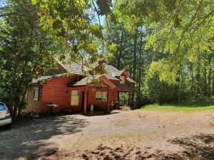 a log cabin in the middle of a forest at Cabaña en Parcela con Tinaja in Trancura +5 photos