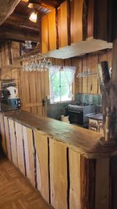 a kitchen with a wooden counter top in a room at Cabaña en Parcela con Tinaja in Trancura