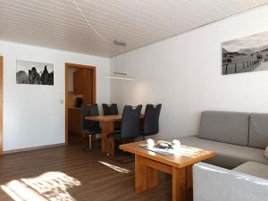 a living room with a couch and a table at 2-Raum FeWo Edelweiß - Hallenbad & Sauna in Fischen