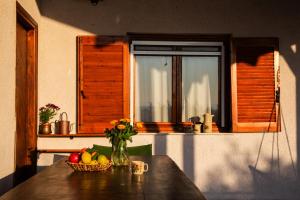 a table with a bowl of fruit and a vase of flowers at Beetle Villa retro country house in Kineta +46 photos