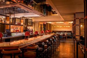 a bar with a row of bar stools at MOXY NYC Times Square in New York