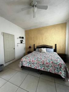 a bedroom with a bed with a floral bedspread at Liah Amplio y Cómodo cuarto privado en Zapopan in Guadalajara
