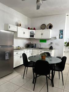 a kitchen with a table with chairs and a refrigerator at Liah Amplio y Cómodo cuarto privado en Zapopan in Guadalajara +1 photo