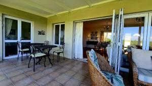 una veranda riparata con tavolo e sedie di Fun at Beach a Kenton-on-Sea