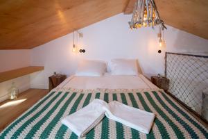 a bedroom with a bed with a green and white rug at Ribeira d'ilhas Shelter in Santo Isidoro