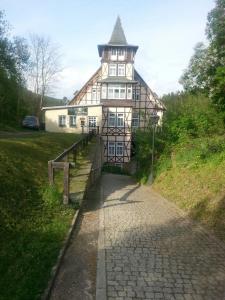 un grand bâtiment avec une tour en haut dans l'établissement Hotel SchwarzaBurg, à Schwarzburg