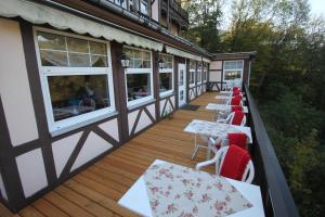 einen Balkon eines Restaurants mit Tischen und Fenstern in der Unterkunft Hotel SchwarzaBurg in Schwarzburg