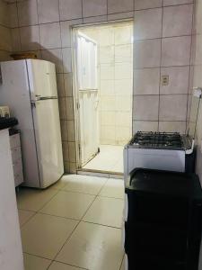 a kitchen with a stove and a white refrigerator at Apartamento no Centro in Patos