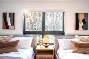 a bedroom with two beds and a window at Tremblant Prestige - Verbier 4-202 in Mont-Tremblant