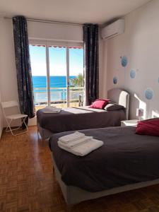 a bedroom with two beds and a view of the ocean at Casa Anna appartamento fronte mare Ventimiglia in Ventimiglia