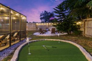 a backyard with a putting green with two golf clubs at Poolside Fun Games Perfect Family Escape in Largo