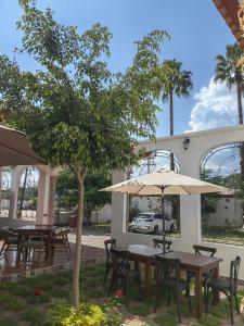 a table and chairs with an umbrella in a yard at Hotel Muñoz de Luna in Huajuapan de León +43 photos