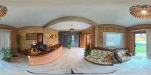 a large living room with a couch and a table at Pousada Askalon in Itaúnas
