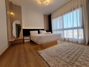 MadinatyにあるMadinaty Elite 3 Bedrooms Apartmentのベッドと大きな窓のある寝室