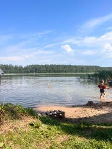 two children playing in the water at a lake at Zacisze u Małgosi in Augustów