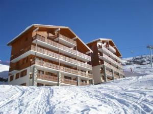 a building on top of a snow covered mountain at Appartement aux Menuires avec cuisine équipée, balcon et animaux admis - FR-1-452-15 in Les Menuires