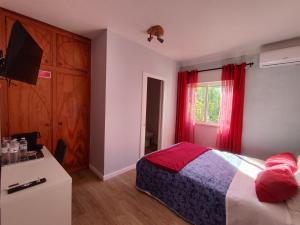 a bedroom with a bed and a window with red curtains at Casa Maria in Loures