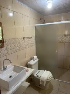 a bathroom with a toilet and a sink and a shower at Lagoa Hospedaria in Imbituba