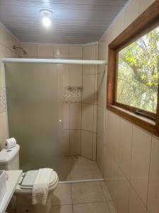 a bathroom with a shower and a toilet and a window at Lagoa Hospedaria in Imbituba +12 photos