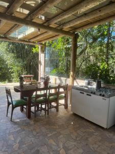 a patio with a table and chairs and a stove at Lagoa Hospedaria in Imbituba