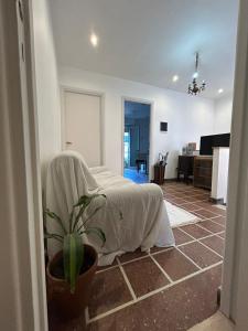 een woonkamer met een bed met een laken erop bij Casa Barracas, habitación privada in Buenos Aires +4 foto's