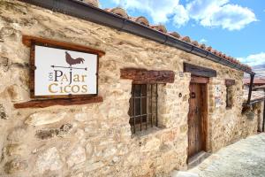 un edificio de piedra con una señal para un zueco de pollo en Mirador del Maestrazgo, en Ejulve
