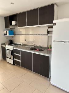 a kitchen with a white refrigerator and a sink at Dpto 9 - Colon - 1 DORMITORIO - PQ ALQUILERES TEMPORARIOS in Colón