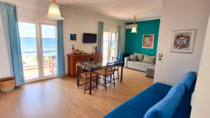 ein Wohnzimmer mit einem blauen Sofa und einem Tisch in der Unterkunft Summer House in Nikiti