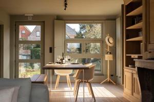 a living room with a table and two windows at Waterfront vacation home in Sint-Amands