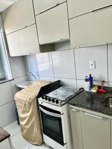 a kitchen with white cabinets and a stove top oven at Apto Amplo e aconchegante px a praia! in São-José-do-Ribamar +62 photos