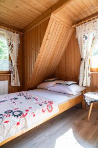 a bedroom with a bed in a wooden house at Gościniec U Ani - pod wieżą widokową Sky Walk, nieopodal szlaków na Polane Rusinową , Gęsią Szyje, Polane Zgorzelisko , Tarasówke i Palenice in Male Ciche