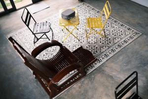 a group of chairs and a table on a rug at MAI HOTAY Lakeside Highland Retreat Homestay in Ðức Lập