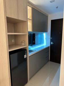 a kitchen with black cabinets and a black refrigerator at Apartment Citra Plaza Nagoya Batam 10-27 in Jodoh