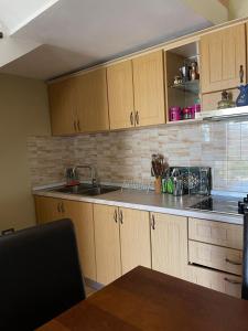 a kitchen with wooden cabinets and a sink at Stone Villa Ballabanac in Krujë +3 photos