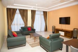 un salon avec deux canapés et une télévision dans l'établissement StayAfrica, à Ouagadougou