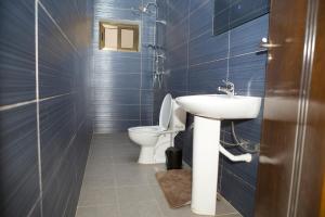une salle de bains avec toilettes et lavabo dans l'établissement StayAfrica, à Ouagadougou 13 autres photos