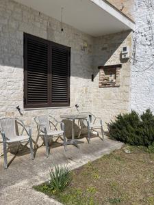 a patio with a table and chairs in front of a building at Stone Villa Ballabanac in Krujë
