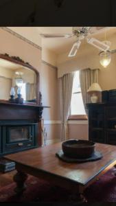 a living room with a table and a fireplace at Daly View Bed & Breakfast in Fremantle