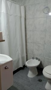 a bathroom with a toilet and a shower curtain at Hotel Centro Naval in Buenos Aires +37 photos