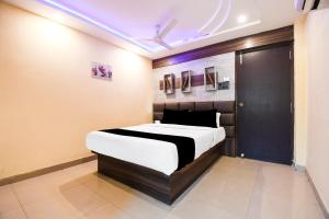 a bedroom with a bed and a purple light at Super Collection O Hirak Road Dhanbad formerly Hirak Inn in Dhanbād