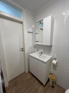 a white bathroom with a sink and a mirror at Apartman Matea - Self Check-in in Osijek +14 photos