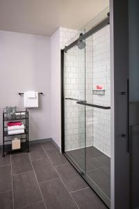 a bathroom with a shower with a glass door at MOXY Denver Cherry Creek in Denver +37 photos